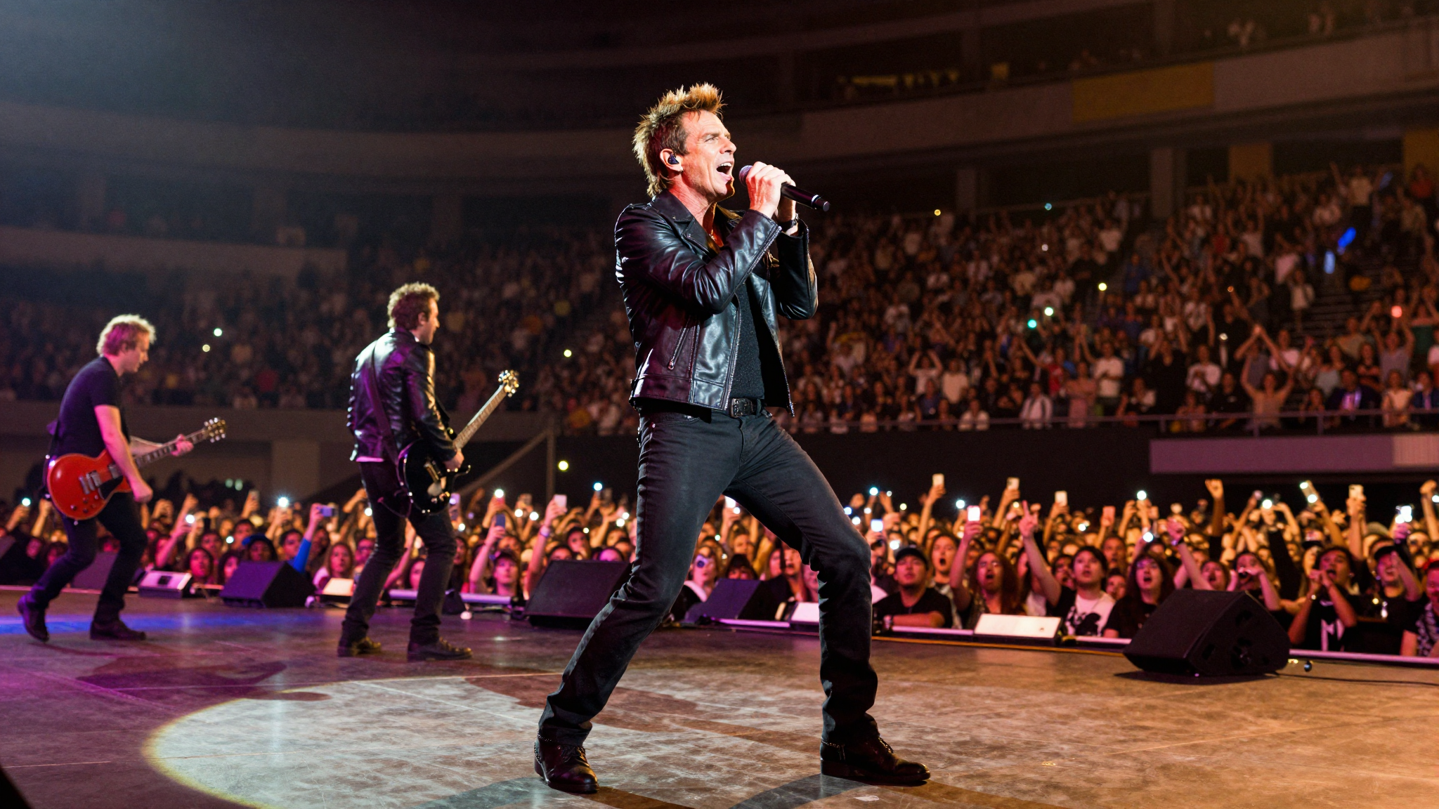Duran Duran in concerto a Milano nel 2011, Simon Le Bon canta sotto i riflettori sul palco di un'arena piena di fan.